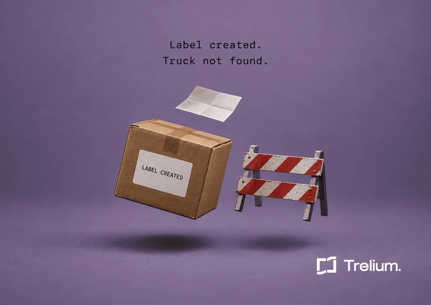 A cardboard box with a shipping label reading LABEL CREATED floats beside a small red-and-white road barrier against a lavender background.